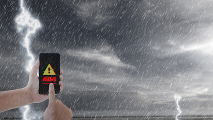 Human hand holds a mobile phone displaying a 404 error message against a backdrop of a stormy sky with lightning and rain, symbolizing connectivity issues and technological failures during bad weather