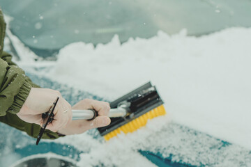 Brushing Snow Off a Car Windshield in Winter