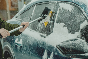 Brushing Snow Off a Car Windshield in Winter