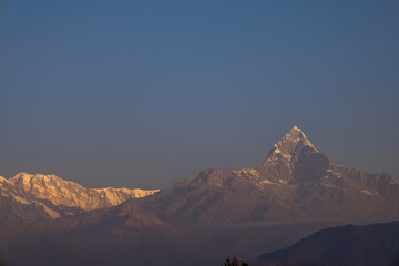 Machhapuchhare (Fishtail Mountain) glowing at sunrise in the Annapurna Himalayas, Nepal. Perfect for travel marketing, tourism ads, website headers, wallpapers, posters and editorial use.