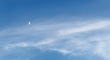 Blue sky background, moon light in white clouds, bright stars shining behind