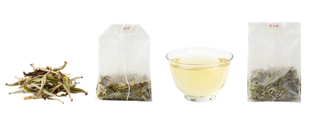 Photograph of two transparent tea bags with dried green and brown herbs, one open with contents spilled, and a clear glass bowl filled with yellow tea liquid, all.