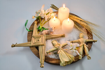 Imbolc altar with brigid's cross, candles, and corn dollies