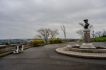 Bust statue on promenade overlooking cityscape and river