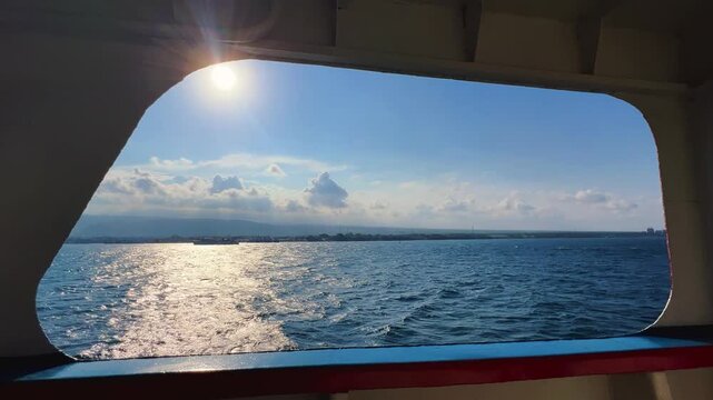 Bali, Indonesia - August 27, 2025: Car and passenger ferries cross the Bali Strait from Gilimanuk Harbor to Ketapang Harbor. View of the strait from the ferry deck. 4К