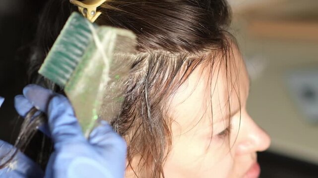 Step-by-step hair coloring process demonstrates techniques for achieving vibrant color. A skilled stylist applies dye with precision and care.