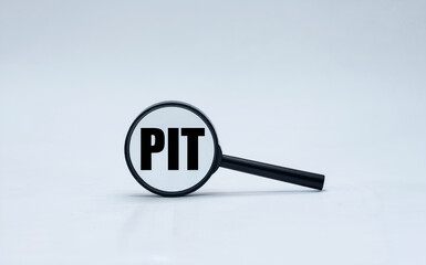 Magnifying Glass Focusing on PIT Text for Personal Income Tax Concept