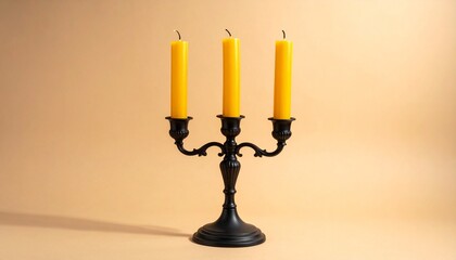 "Vintage black candelabrum with three tall yellow candles on a warm beige background."