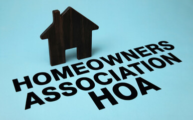 Homeowners Association HOA Text with Wooden House Model on Blue Background