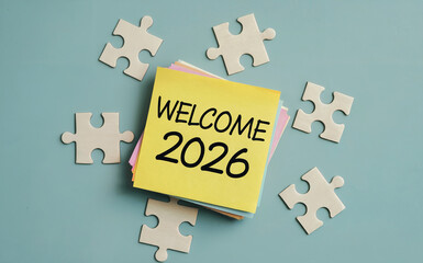 Welcome 2026 Text on Yellow Sticky Note with Jigsaw Puzzle Pieces