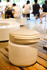 Minimalist round cushioned stool on wooden table in modern cafe interior