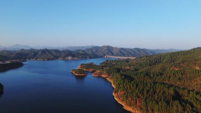 Cinematic aerial drone pull back and pan left revealing a majestic mountain lake landscape. UHD 4K 10-bit nature scenery.