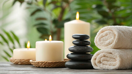 Relaxation setup with candles, stones, and towels in a tranquil setting during day time