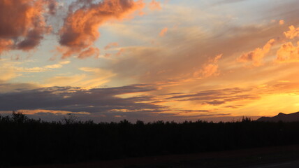 Breathtaking Sunset Over Desert Mountains with Silhouetted Road and Golden Hour Sky