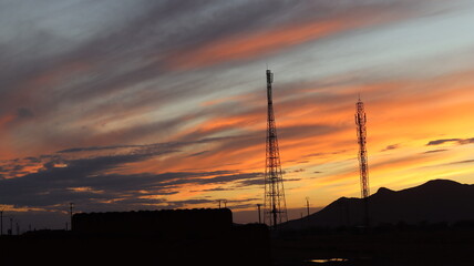 Breathtaking Sunset Over Desert Mountains with Silhouetted Road and Golden Hour Sky