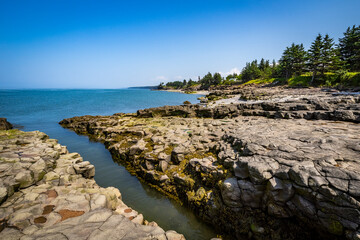 Rocky rugged coast of the Bay of Fundy at the Black Rock Lighthouse on the western side of Nova Scotis Canada