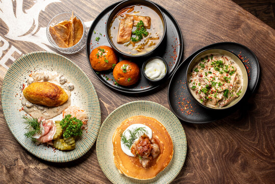 A mouth-watering spread of traditional Eastern European dishes, featuring savory potato dumplings, rich soups, and fluffy pancakes on a rustic wooden table.