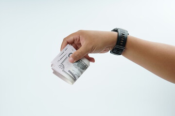 Hand holding US dollar banknote on white background representing payment, cash transaction, financial exchange, income, salary, and money concept with copy space.