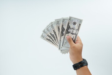Hand holding US dollar banknote on white background representing payment, cash transaction, financial exchange, income, salary, and money concept with copy space.