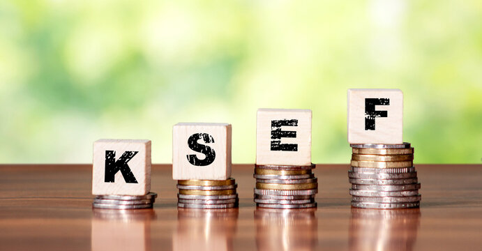 Conceptual image of KSEF letters placed on wooden blocks over a stack of coins. Represents financial systems and tax compliance in a modern economic context.