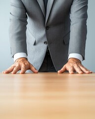 Businessman in Gray Suit with Hands on Table Symbolizing Decision-Making and Leadership Tactics