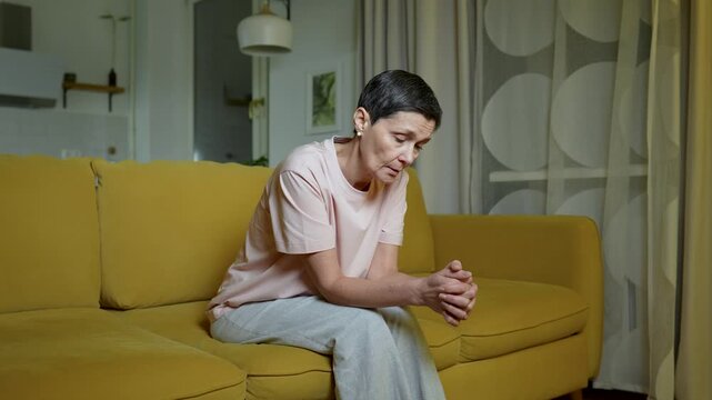Upset senior woman after brawl with husband sits alone with signs of anxiety and depression, lady deeply sighing shaking head in disbelief with disappointed expression, marriage relationships crisis.
