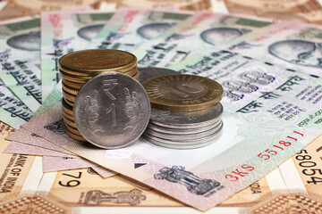Close-up image of Indian rupee notes (INR) of different values and stack of coins. Concept of cash savings, financial profit and security, Indian economy.