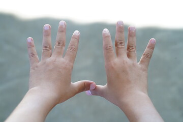 Young child's hands stretched out showing ten fingers with natural skin tones reflecting innocence and childhood joy against a soft blurred background.