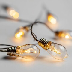 Close up of glowing Edison bulb string lights on a neutral background
