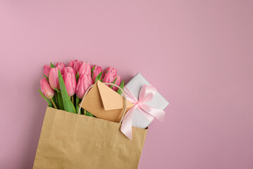 Gift Bag with Pink Tulips and Gift Box on Pink Background. Valentine's or Mother's Day Celebration