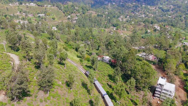 Drone Tracking Shot of  Train Moving Through Green Lands