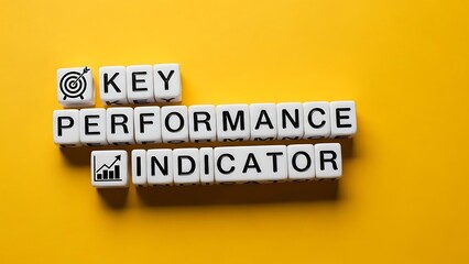 White lettered alphabet blocks spelling out key performance indicator on a yellow surface
