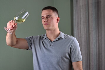 white man holding a glass of white wine