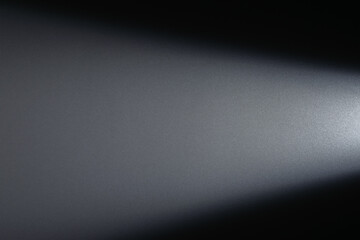 Naklejka premium A powerful, focused beam of white light emanating from a spotlight in a dark room creates striking contrast and atmosphere. Lighting equipment backstage.