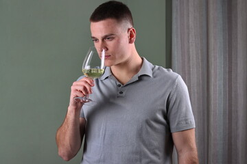 white male smelling his glass of white wine