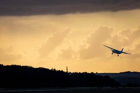 Aircraft taking off into the sunset, Image shows a cessna 208 taking off during golden hour of sunset