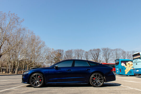 February 20, 2021, Seoul, South Korea - A dark blue Audi S7 sedan parked in an outdoor parking lot on a sunny day.