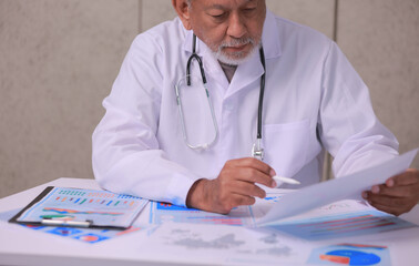 Senior medical professional reviews data privacy management report with serious expression while holding document paper