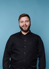 Obraz premium Smiling man in black shirt against blue background.