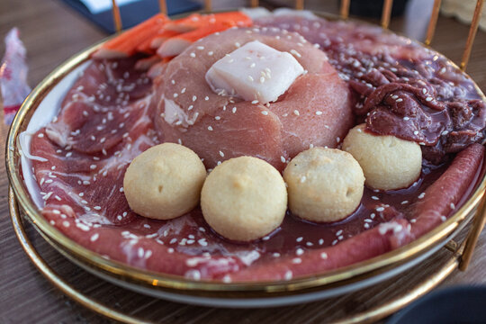 Close up of fresh raw sliced pork meat on a plate, prepared for Thai style BBQ or Moo Krata, high protein ingredient for grill and hot pot, delicious meat textures photography.