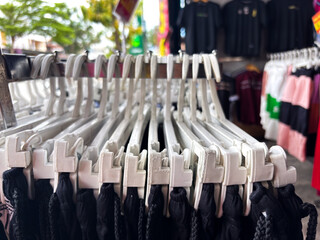Clothing hangers with black garments on display