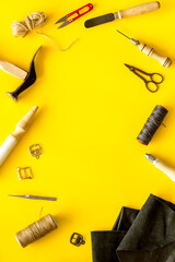 Frame flat lay of leather craftsman or shoemaker tools and equipment, top view