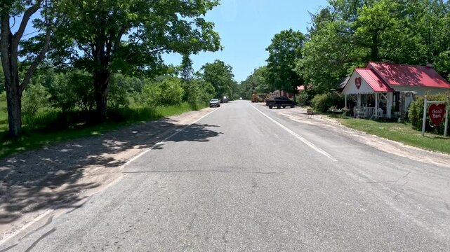 Driving Through a Small Town in Northern Michigan, USA. Car point of view driving through the charming small town of Good Hart, Michigan, USA. 