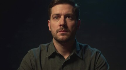 Silent resolve waiting for phone call, man sitting with vintage rotary telephone, cinematic moody portrait, serious interrogation concept