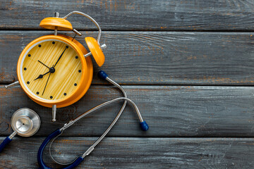 Stethoscope and vintage alarm clock, top view. Time for medical checkup