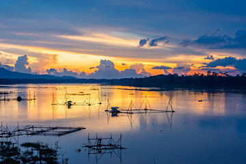 Golden Sunset Over Calm Lake with Fishing Nets and Reflections at Dusk