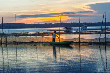 Golden Sunset Over Calm Lake with Fishing Nets and Reflections at Dusk
