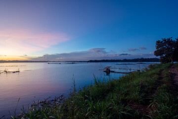 Golden Sunset Over Calm Lake with Fishing Nets and Reflections at Dusk