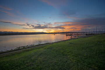 Golden Sunset Over Calm Lake with Fishing Nets and Reflections at Dusk