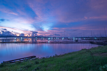 Golden Sunset Over Calm Lake with Fishing Nets and Reflections at Dusk